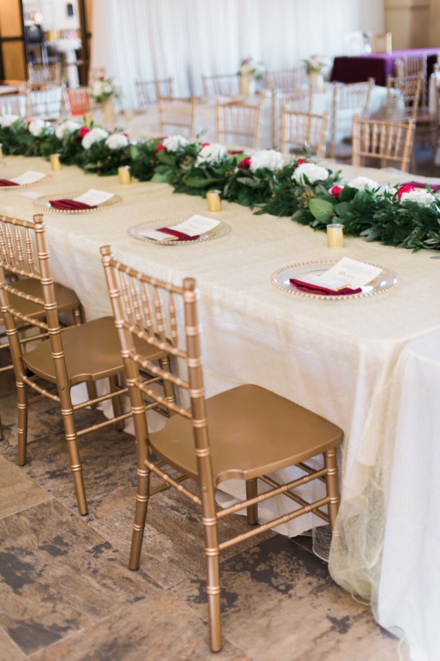 Elegant wedding table setting with gold chairs floral decor