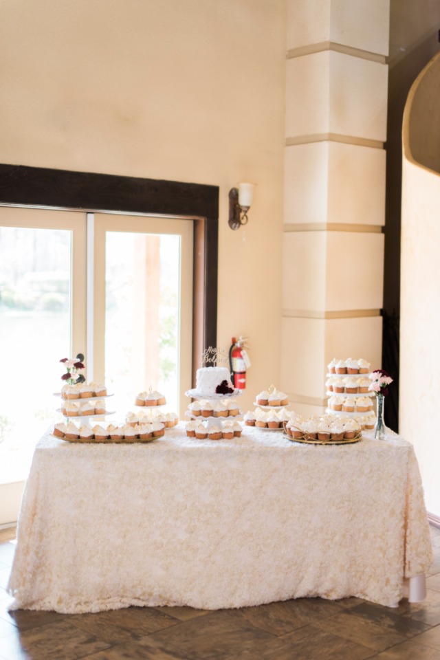Wedding cupcakes and small cake on lace tablecloth