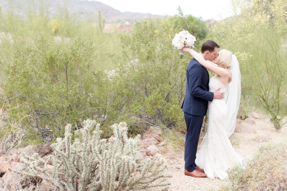 bride and groom kiss in the desert