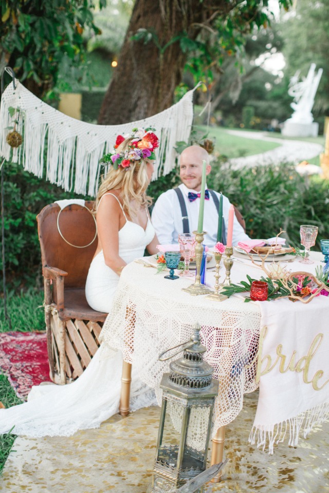 bride and groom at boho sweetheart table