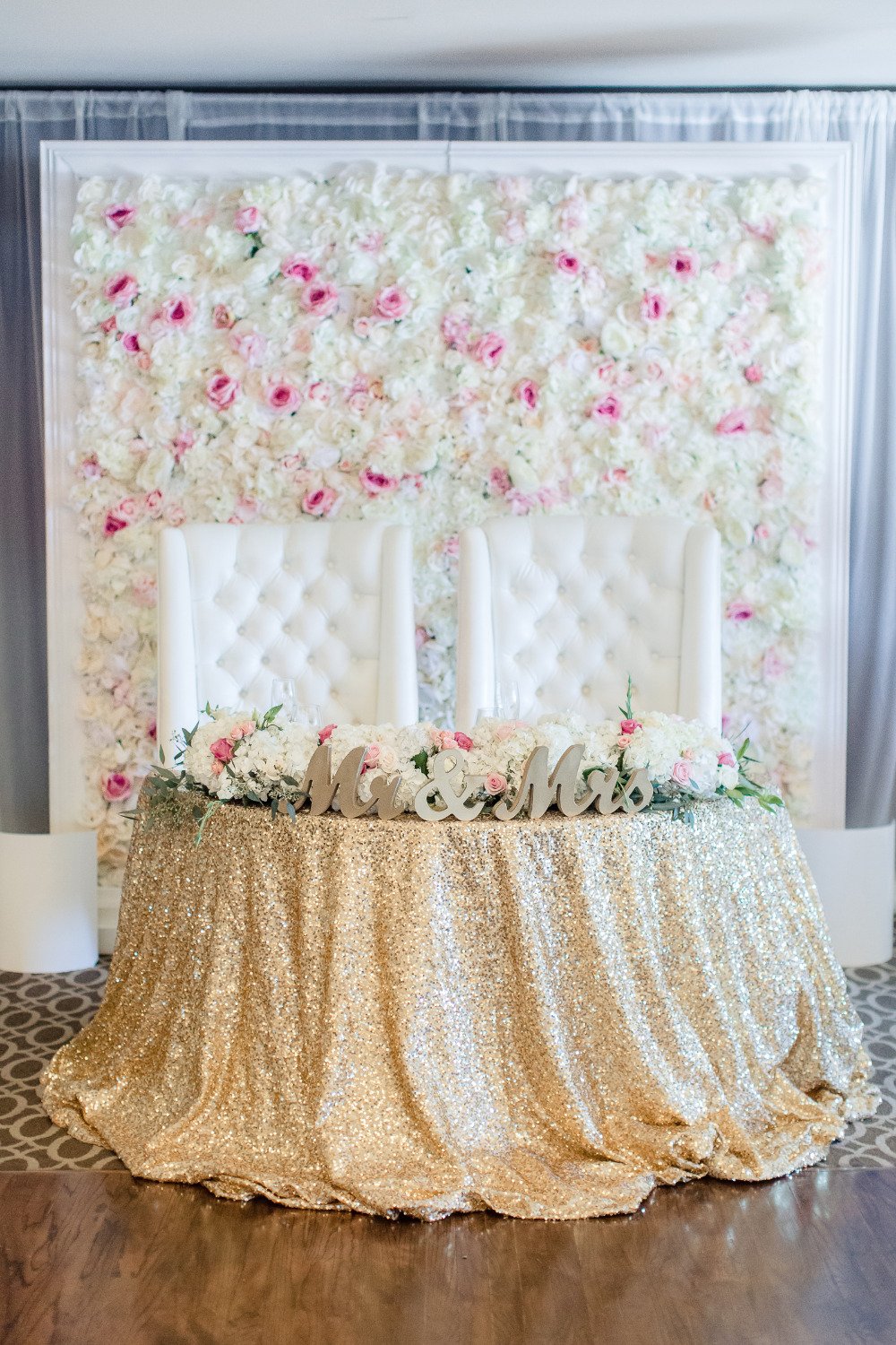 wedding sweetheart table with flower backdrop