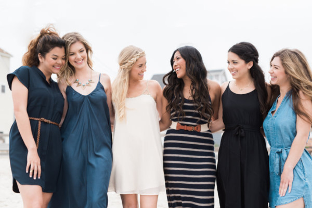 Diverse women friends smiling in dresses at the beach