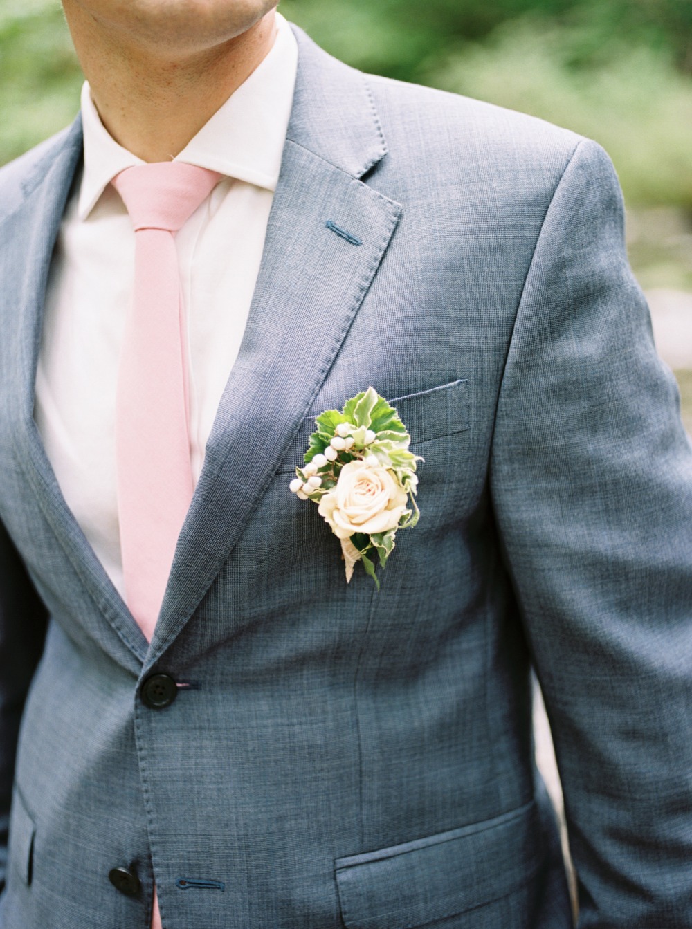 Groom's gray suit with pink tie and boutonniere