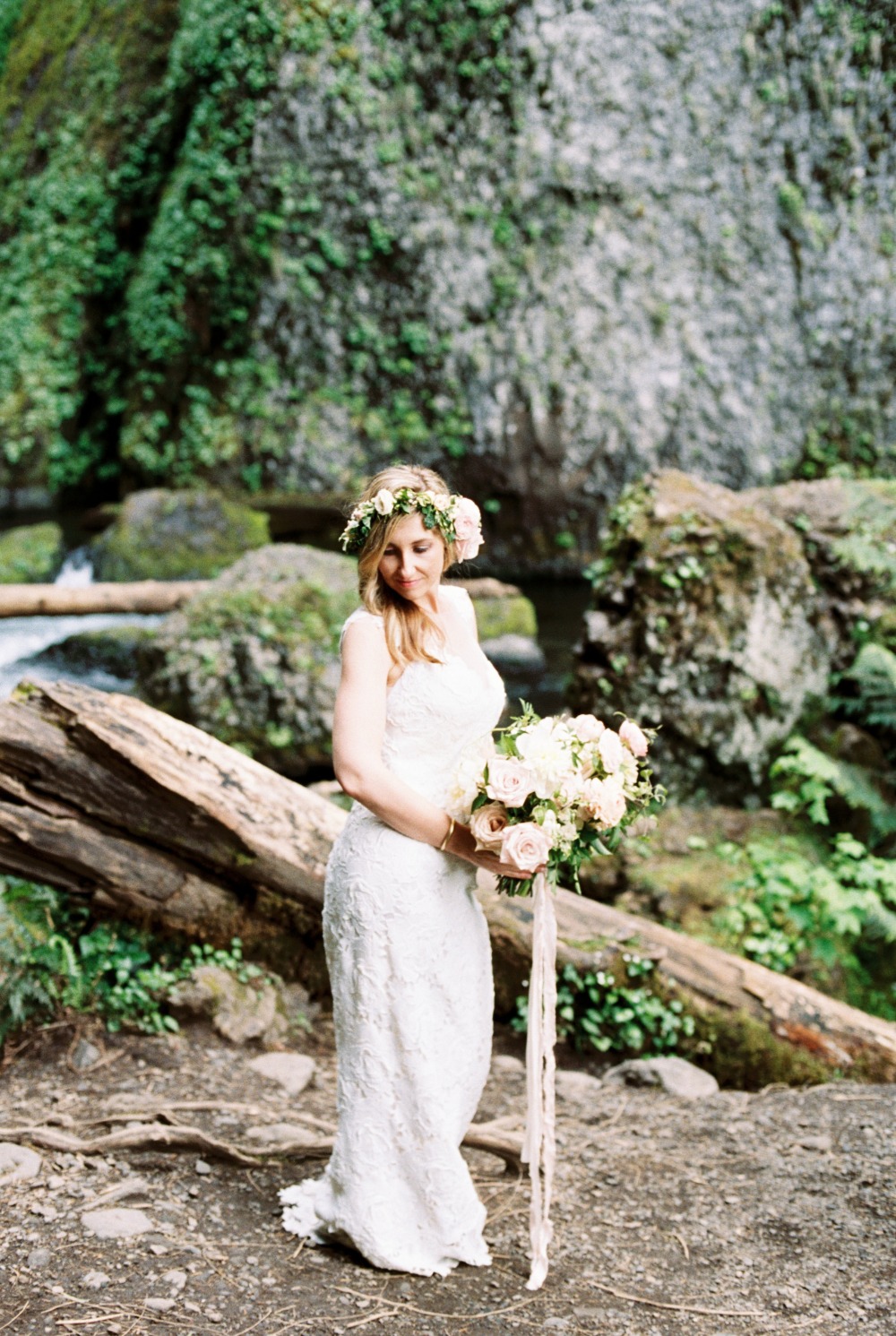 Bride with flower crown and bouquet at waterfall location