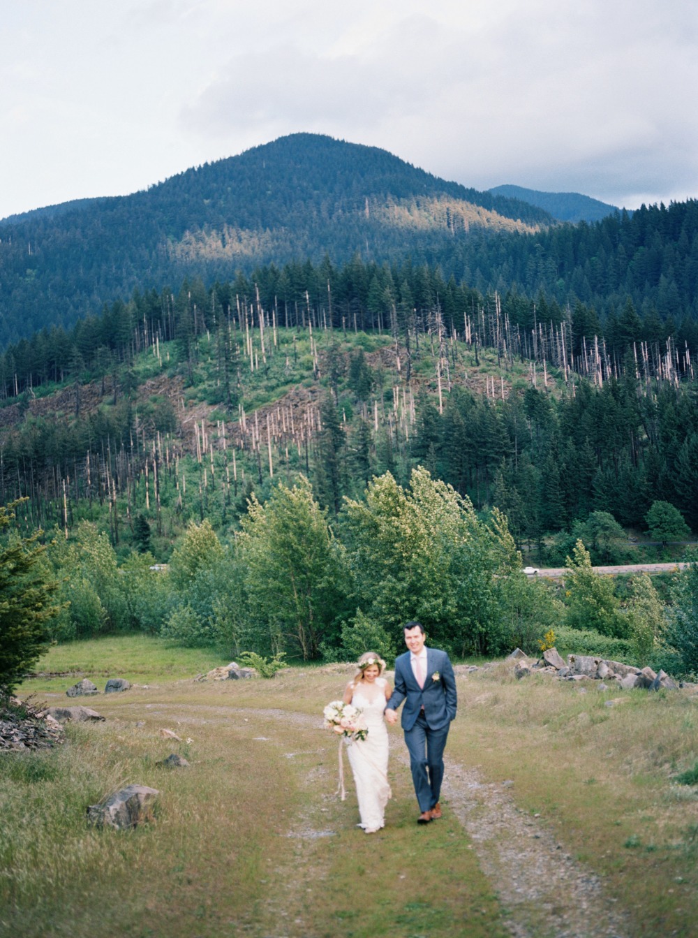 Bride and groom walking on mountain path