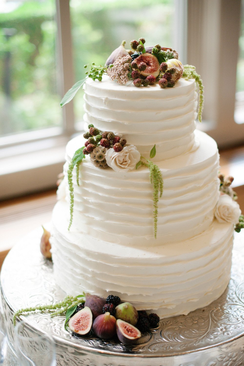white wedding cake with draped florals