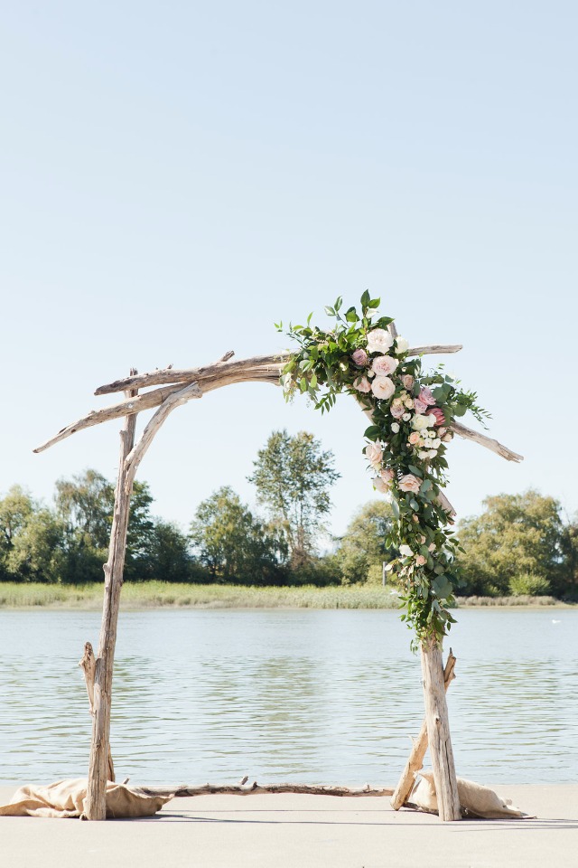 driftwood wedding arch with asymmetrical flower accent