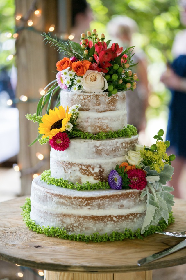 flower topped nearly naked wedding cake