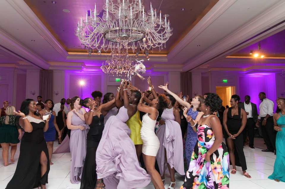 Bridesmaids catch bouquet at elegant wedding reception