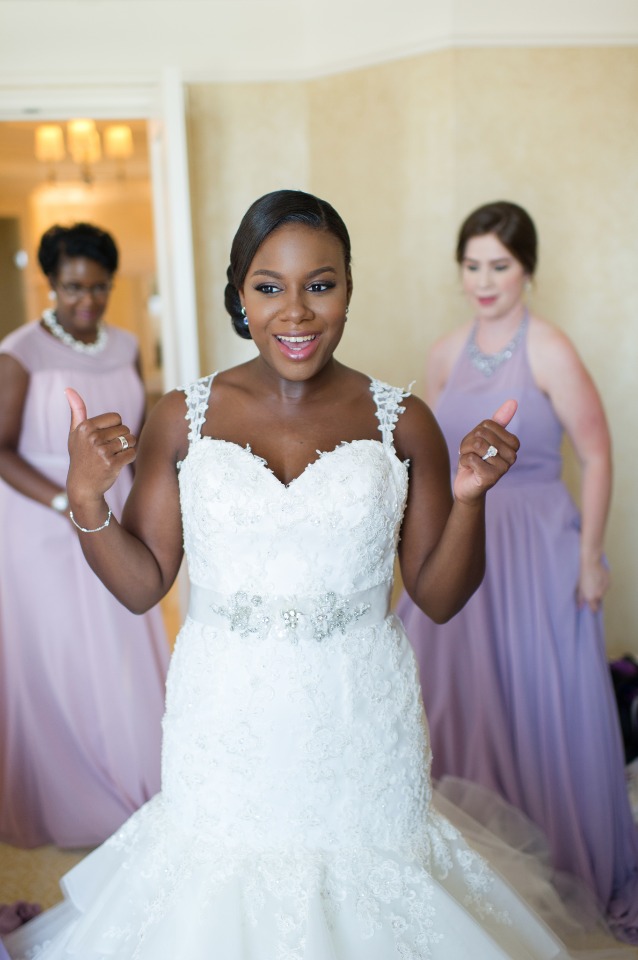 Happy bride in her wedding dress gives two thumbs up