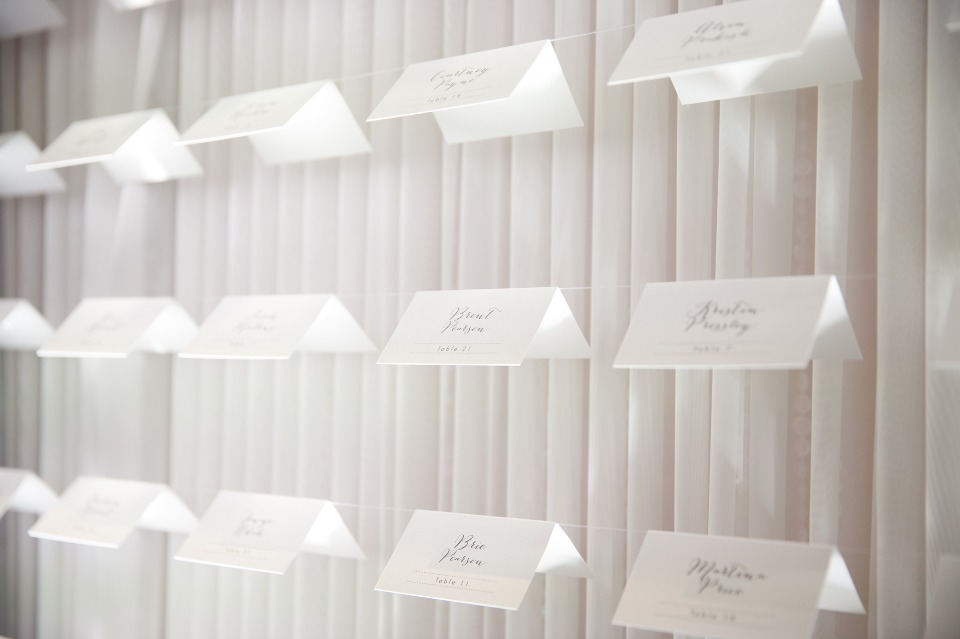 Elegant wedding escort card display with white backdrop