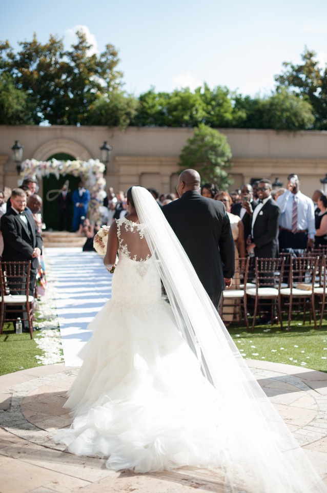 Bride walks down aisle at outdoor wedding ceremony