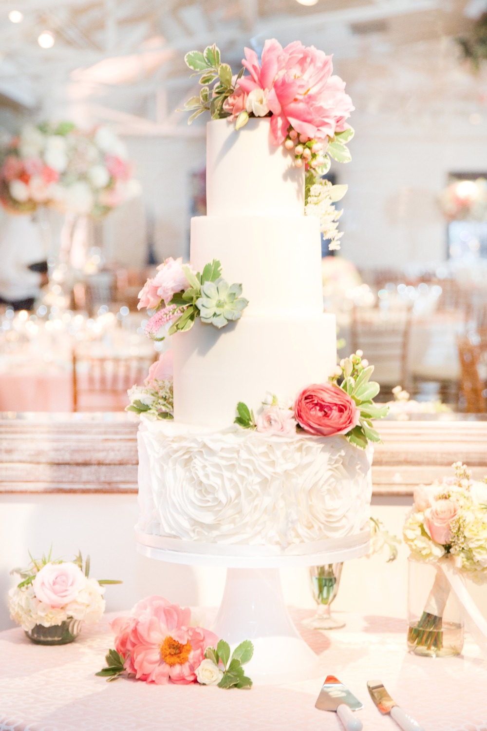 Four tier white wedding cake with florals