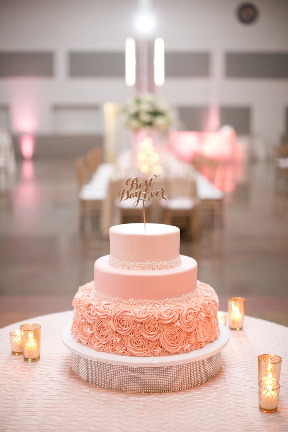 Pink wedding cake with gold topper