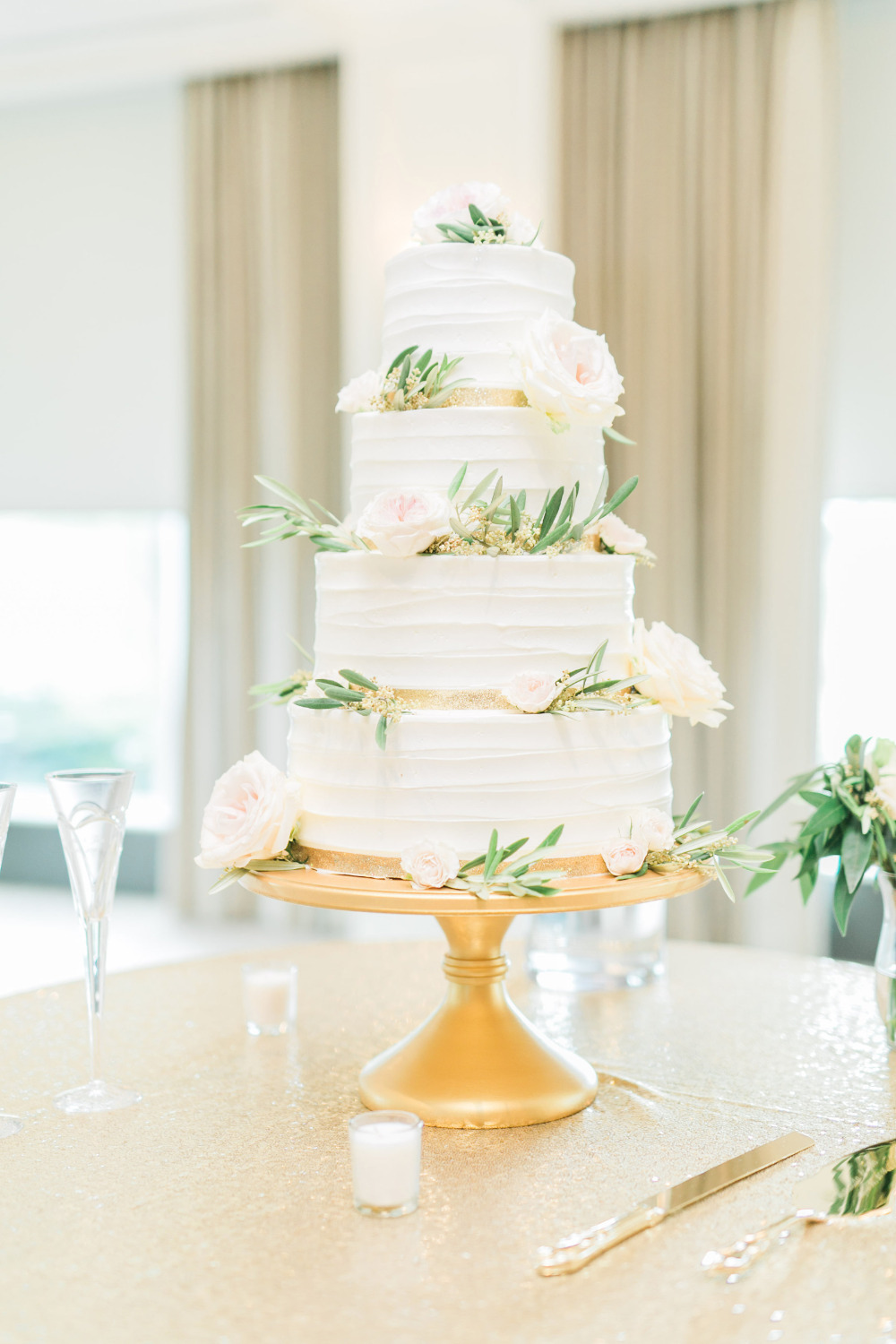 white wedding cake with gold ribbon