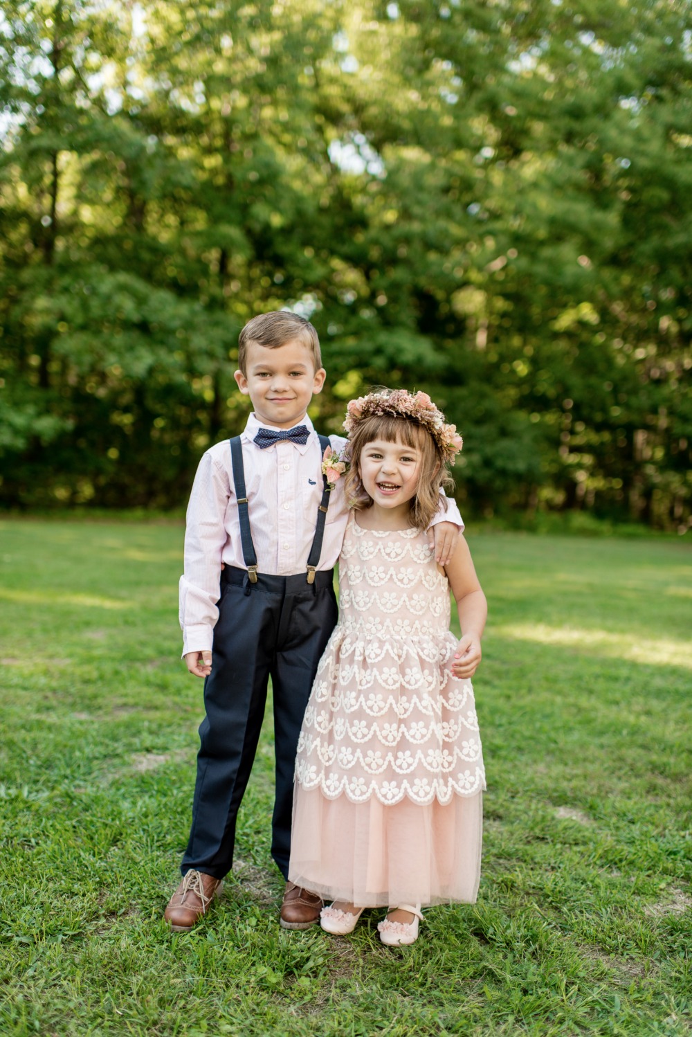 Adorable flower girl and ring bearer smiling outdoors