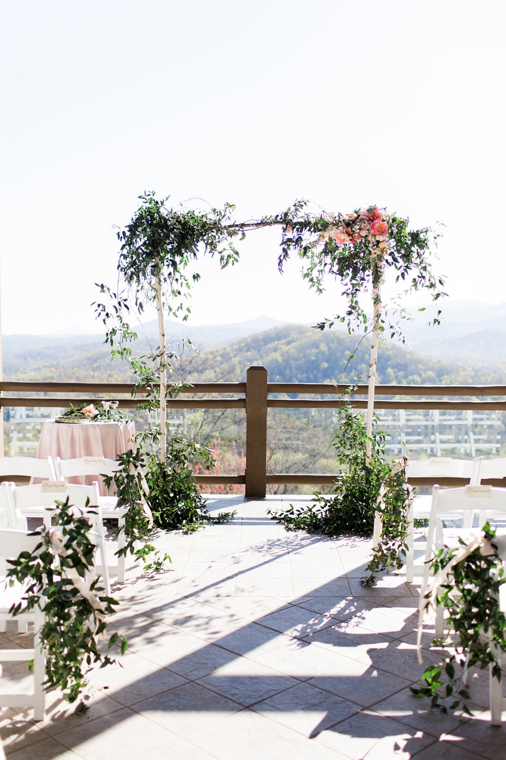 Birch wedding arbor with floral and leafy green details