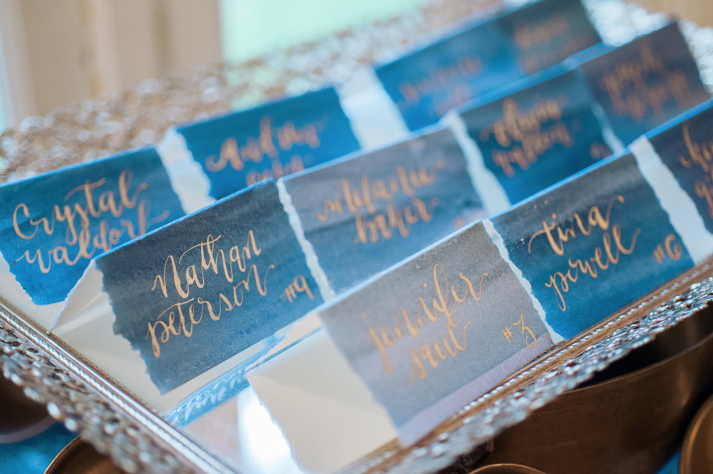 blue watercolor escort cards with gold script names