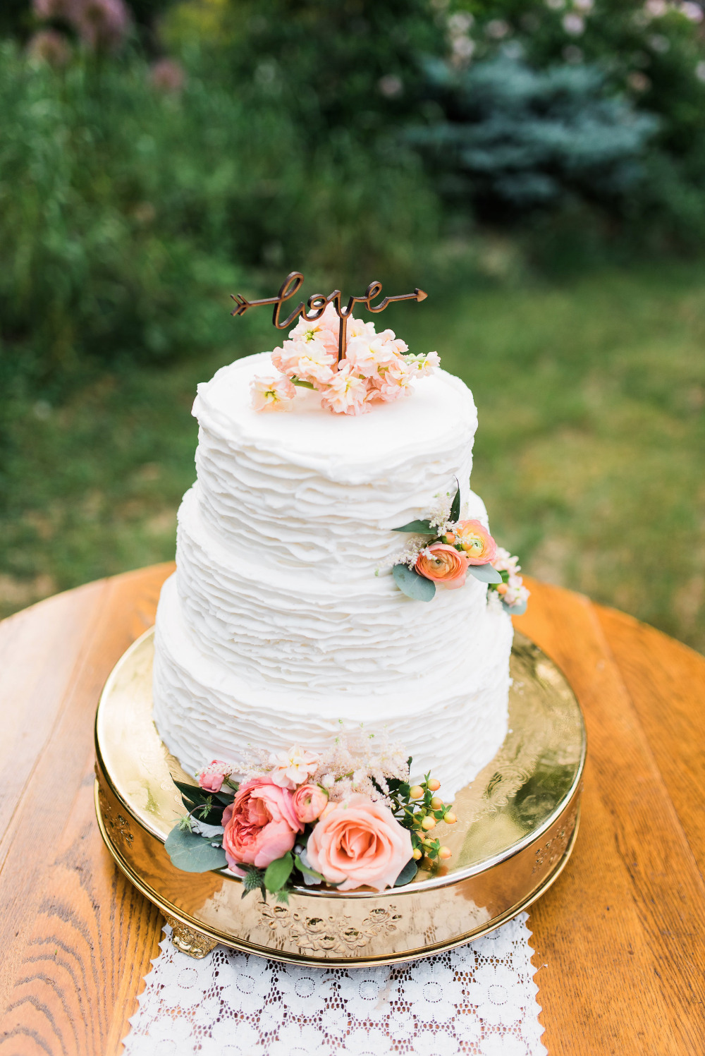 ruffled wedding cake with love topper