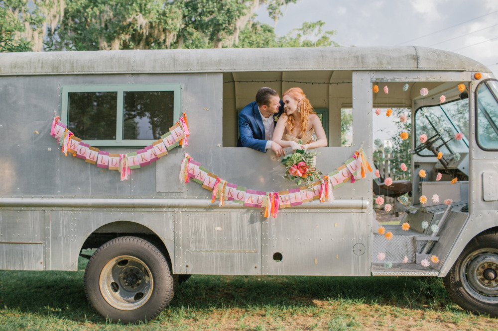Couple in vintage truck with I would travel any road banner