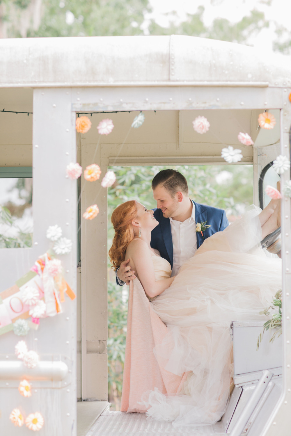 Bride and groom embrace on decorated vintage trolley