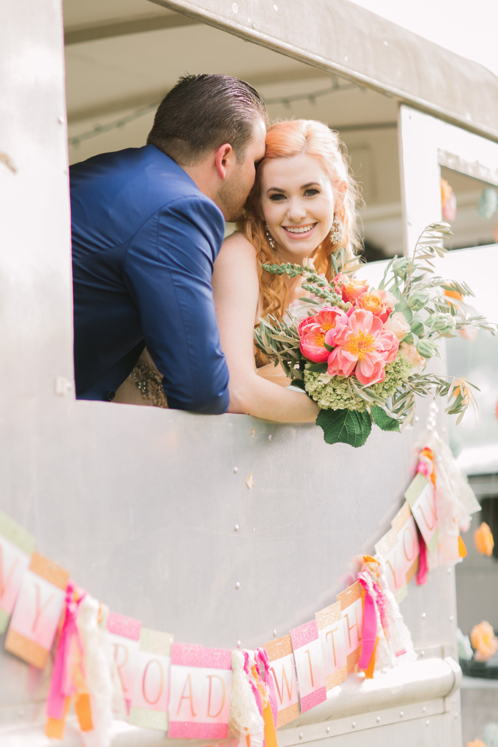 Happy couple embraces in vintage camper, Road With You banner
