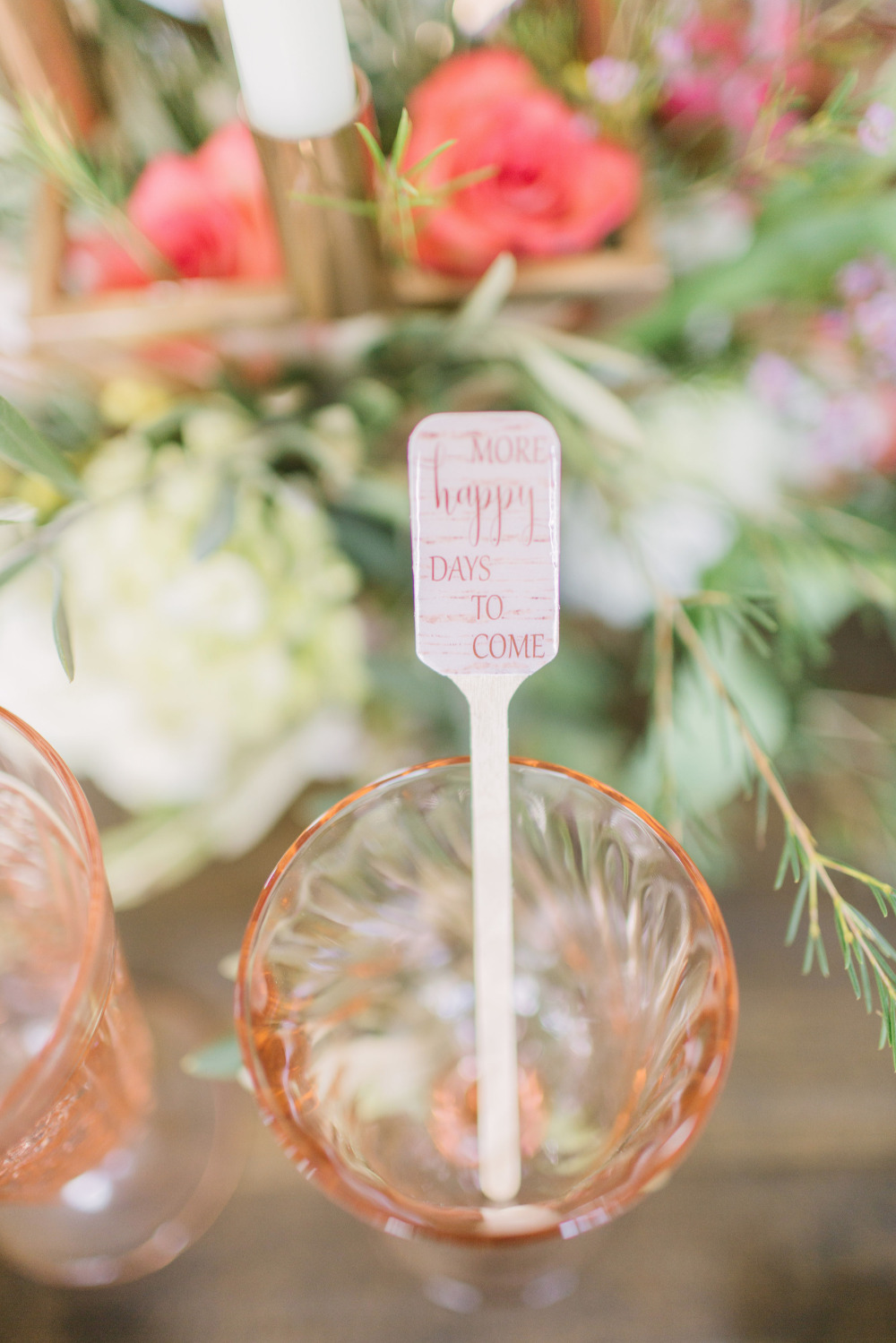 Pink glass with More Happy Days to Come sign