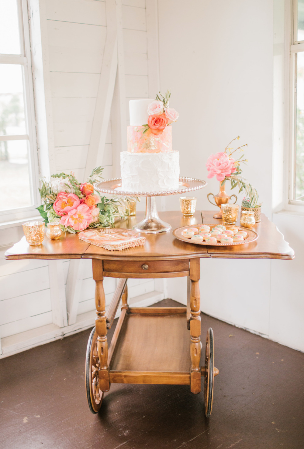 Elegant wedding cake and desserts on vintage serving cart