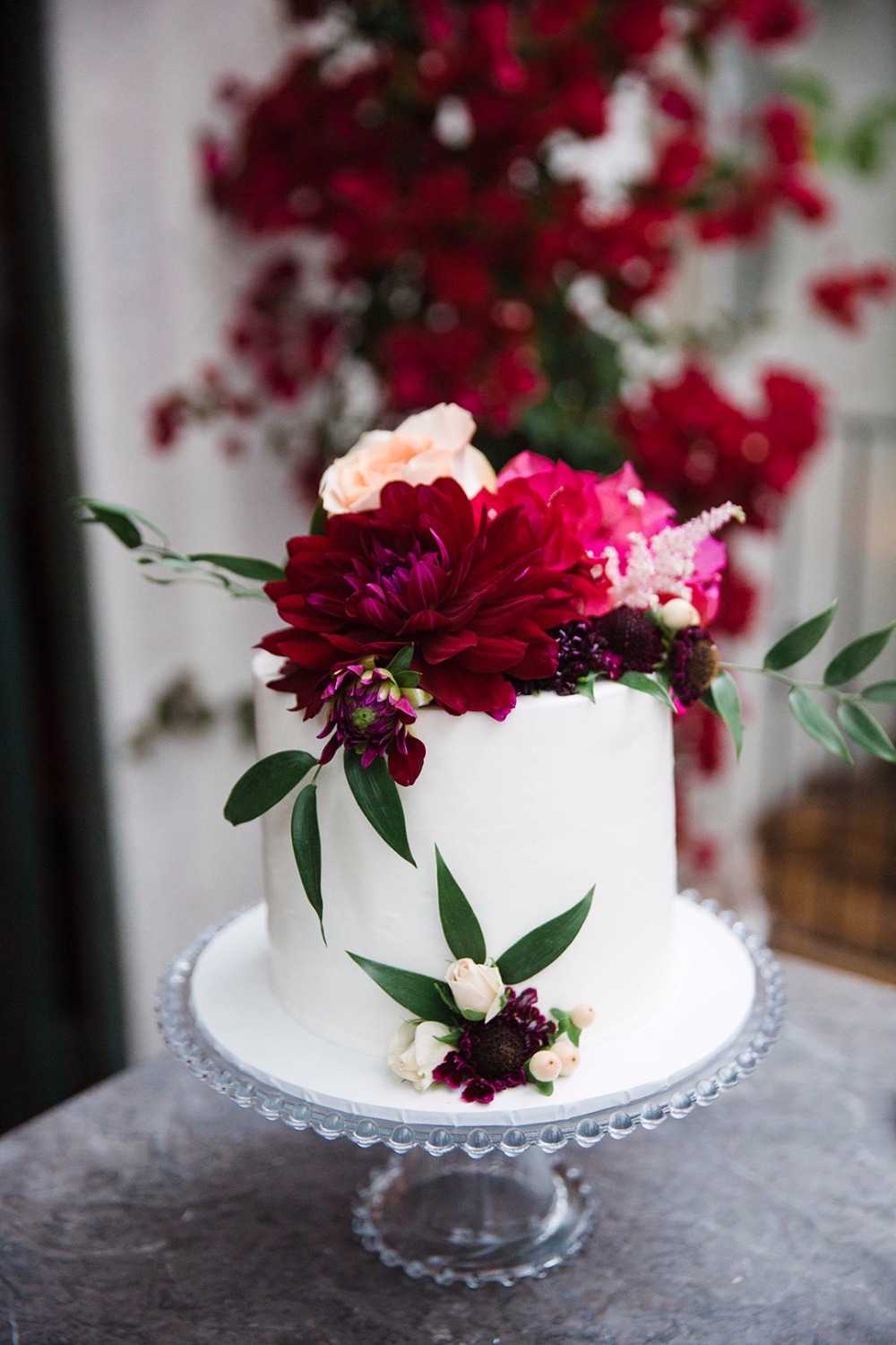 Sweetheart wedding cake with red, pink and peach florals