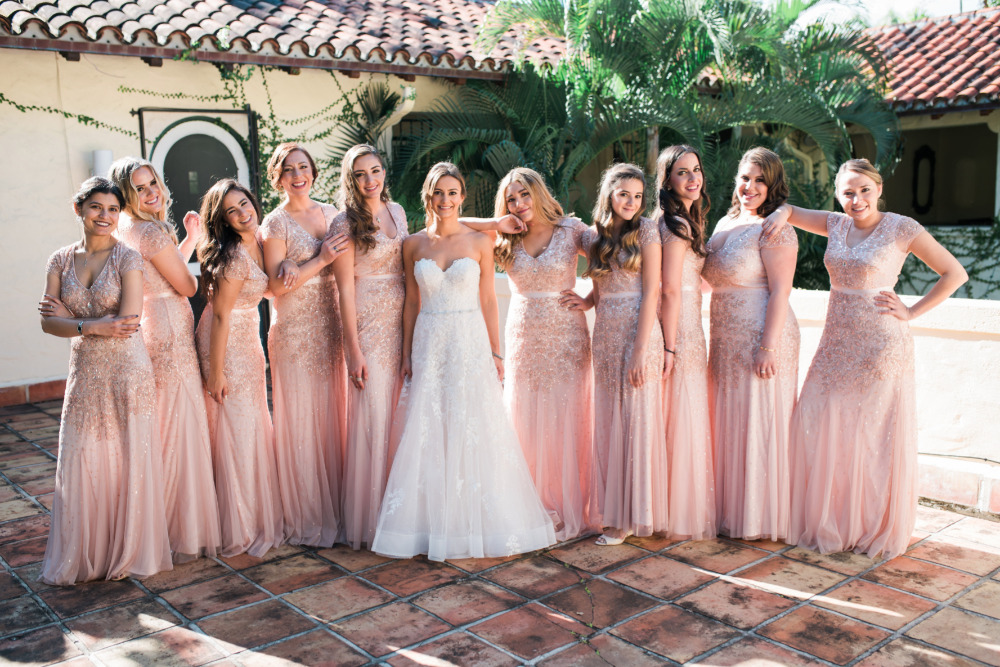 Bride and bridesmaids in pink gowns at outdoor wedding