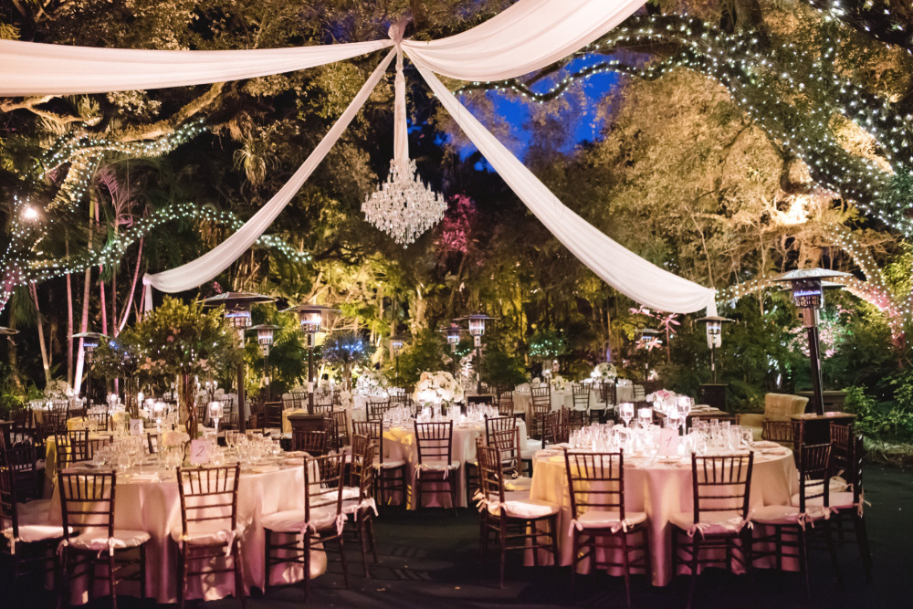 Elegant outdoor wedding reception with draped fabric lights