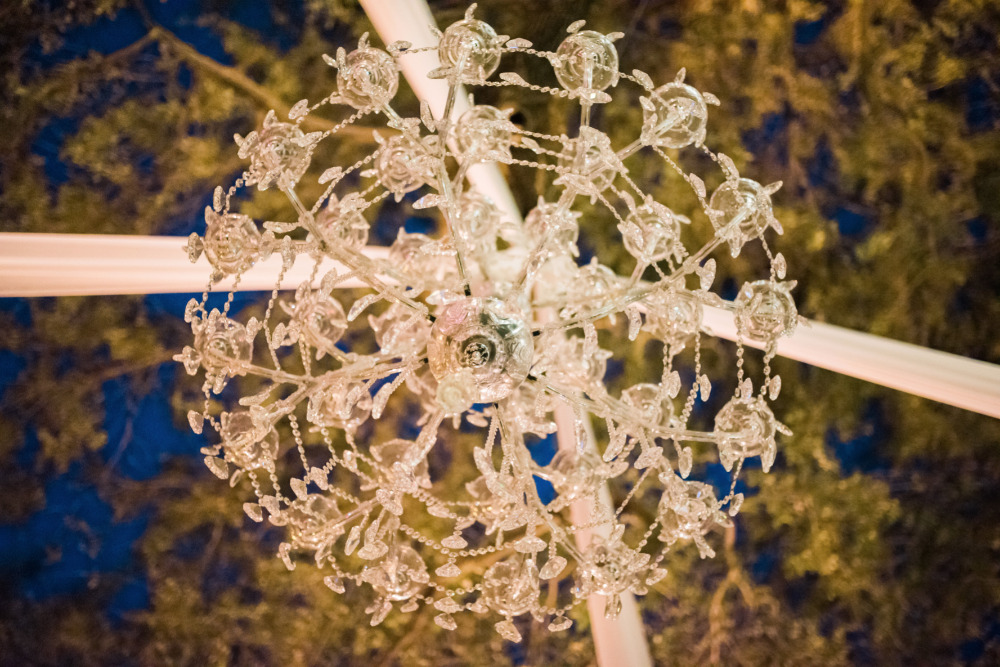 Elegant crystal chandelier hanging outdoors at night