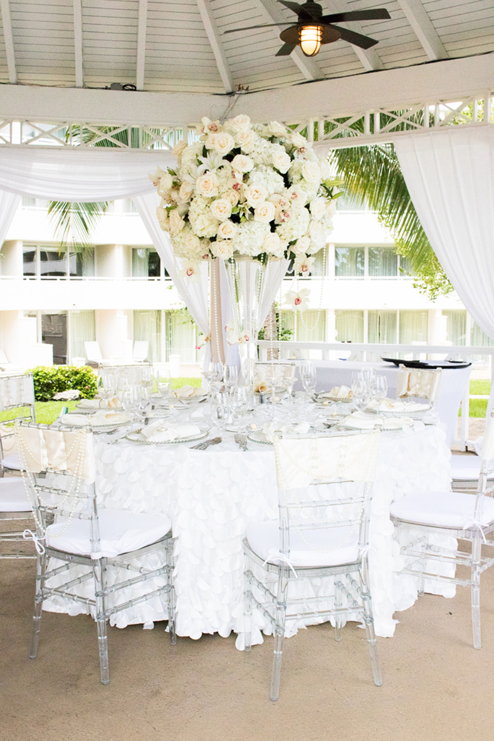 Elegant white wedding reception table with floral centerpiece