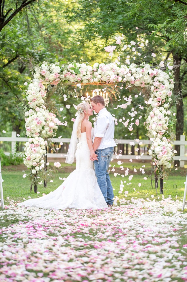 raining flower petals under this glam floral wedding arch