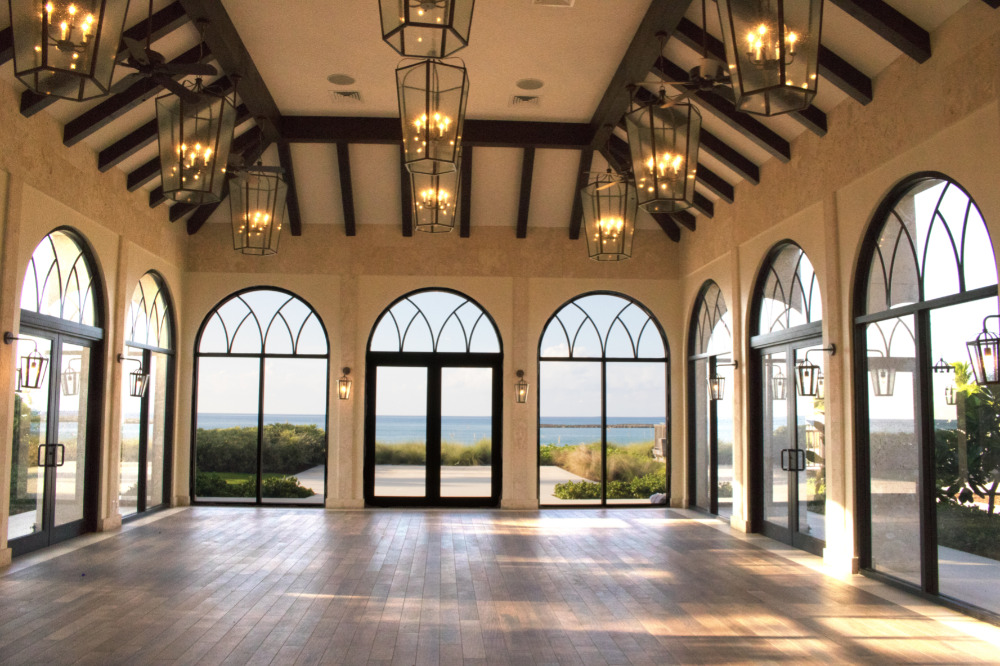 Ocean view event space with arched windows and elegant lighting