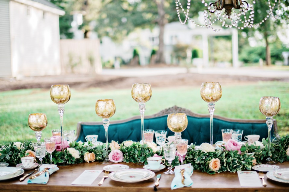 gilded glass goblets and floral runner decorate this glamorous wedding table