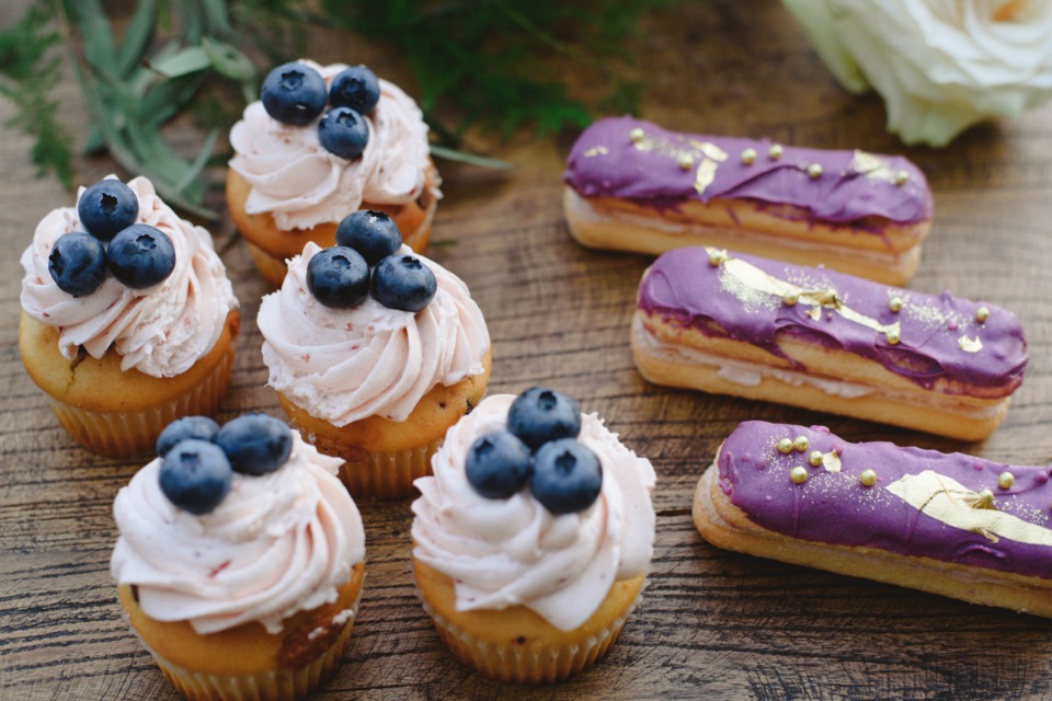 blueberry topped cupcakes and purple and gold eclairs
