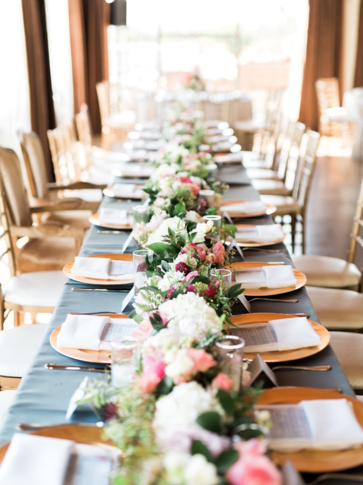 family style wedding seating with dusty blue linens and gold chargers