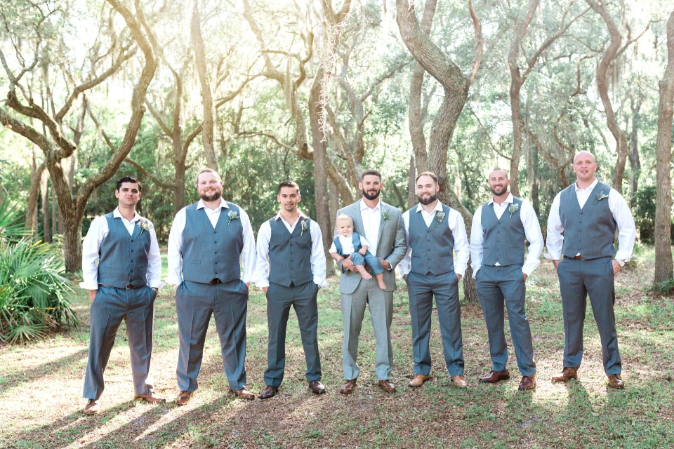 groomsmen in charcoal gray vests and slacks