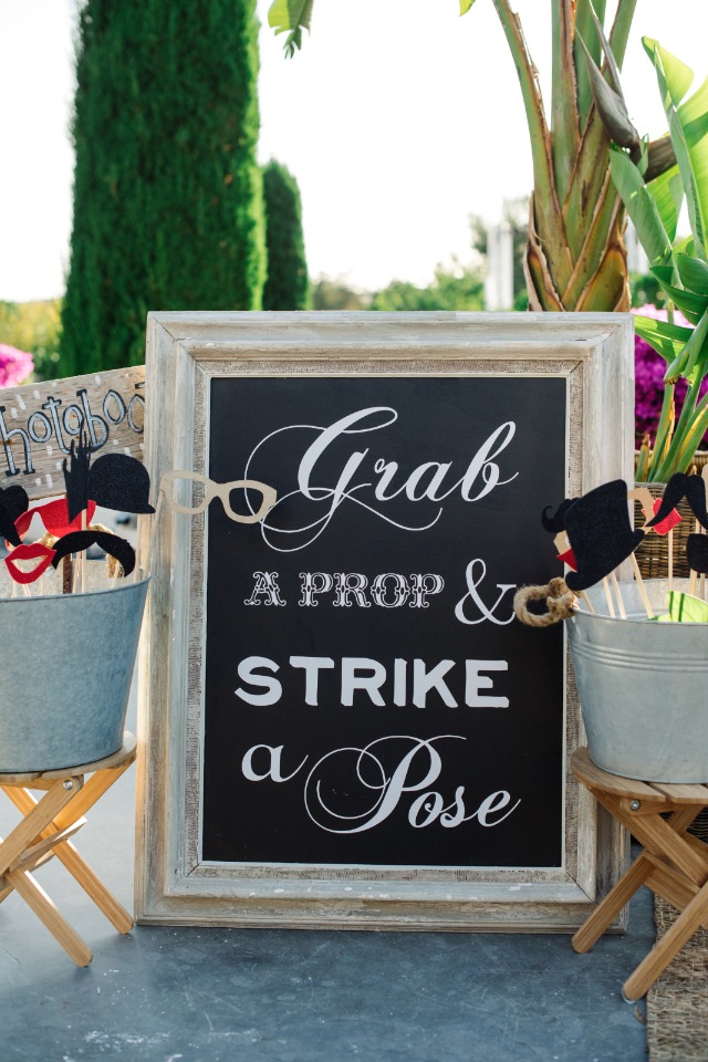 grab a prop and strike a pose photo booth sign