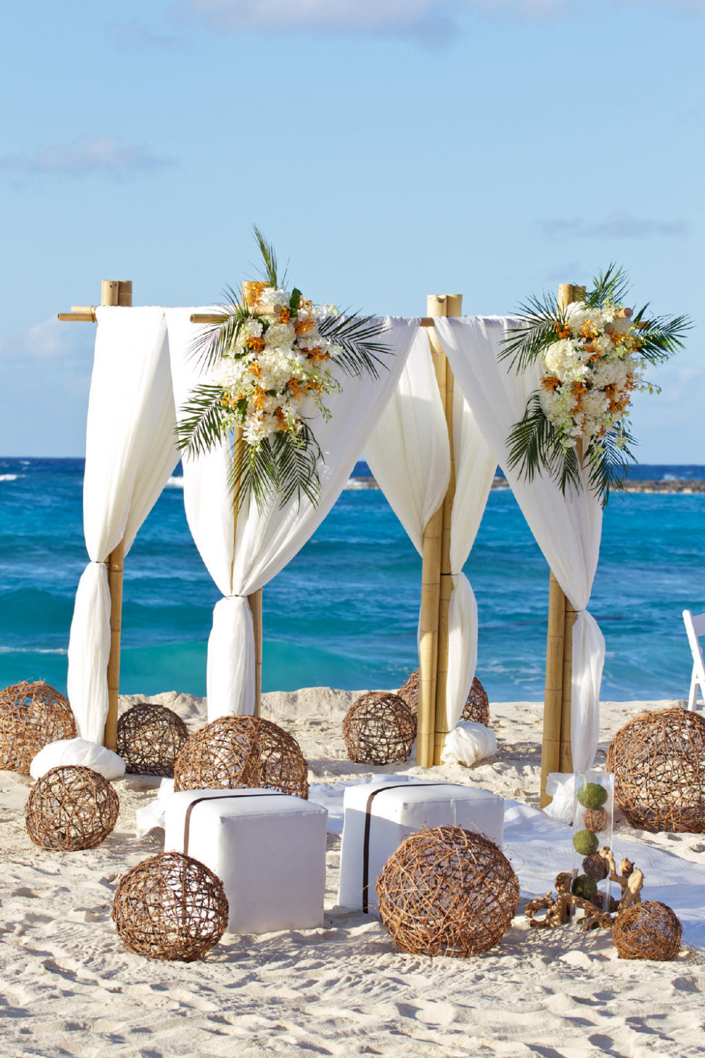 Beach wedding ceremony setup with floral arch