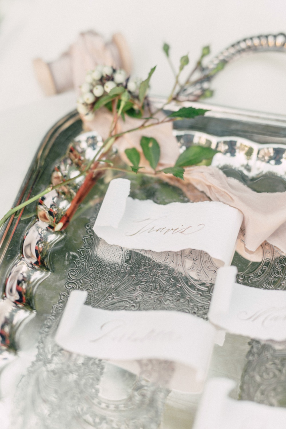 Elegant wedding place cards on silver tray with flowers