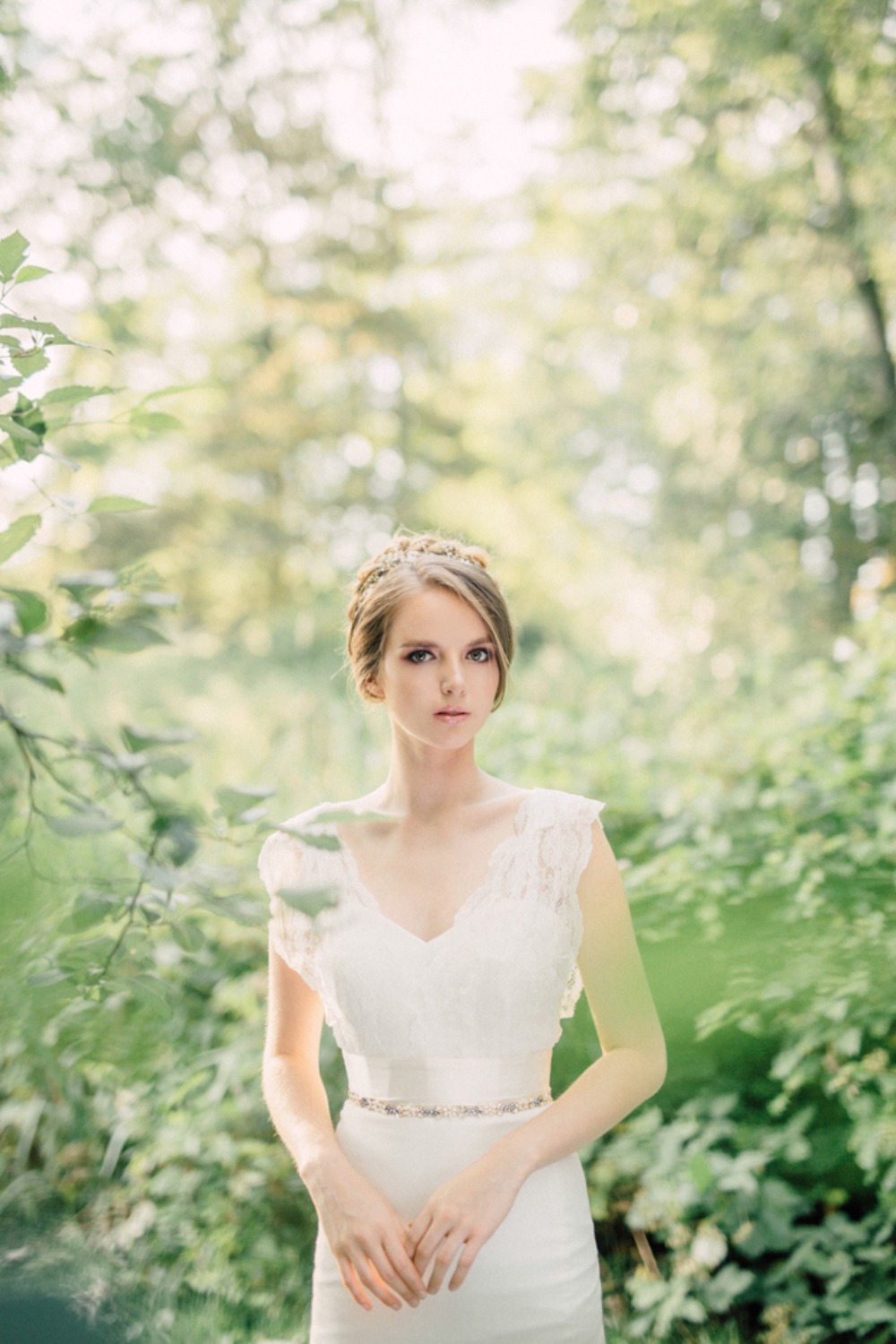 Beautiful bride in white lace gown outdoors