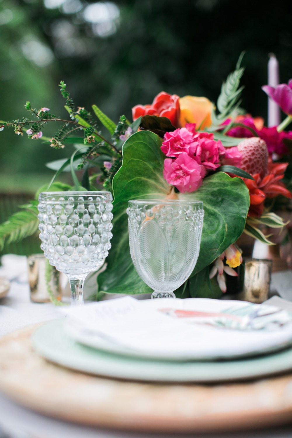 Elegant tropical wedding table setting with glassware