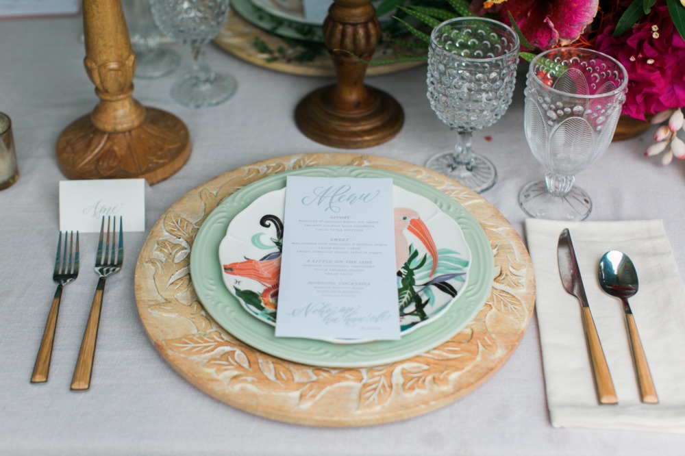 Elegant place setting with tropical bird plates and menu