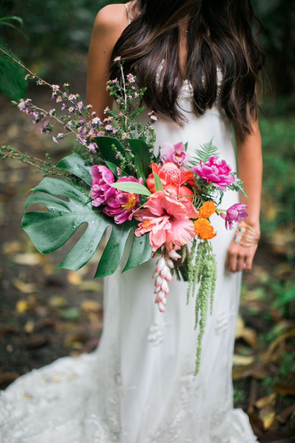 Woman holds vibrant tropical flower bouquet wedding