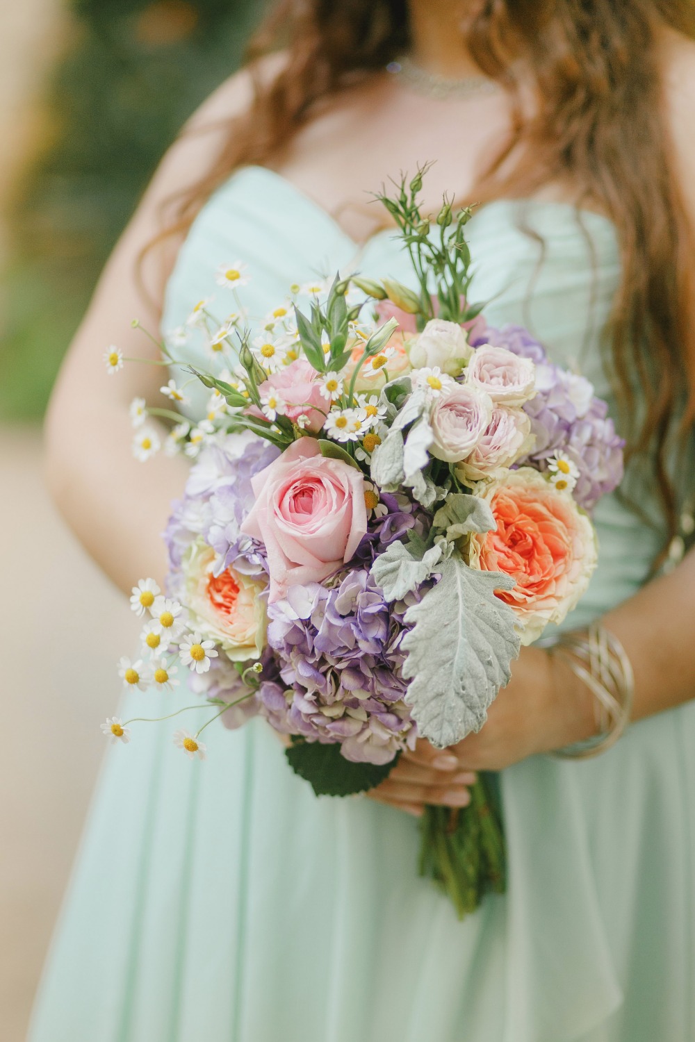 Colorful flower bouquet held by woman in green dress