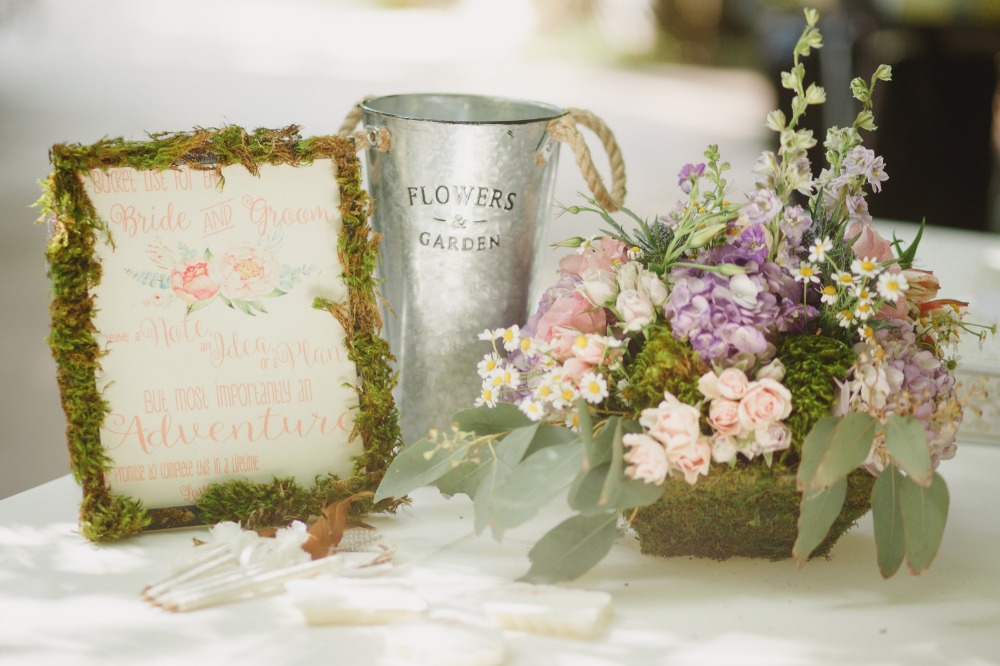 Wedding decor with a sign, flowers and a rustic metal bucket
