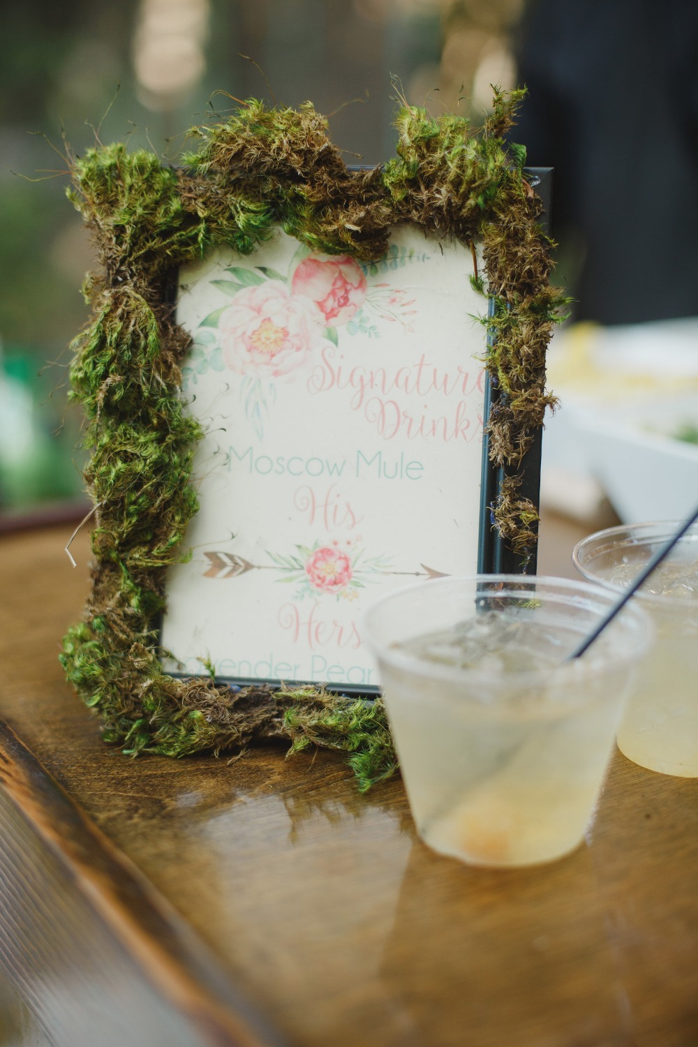 Rustic wedding bar sign with moss frame and refreshing cocktails