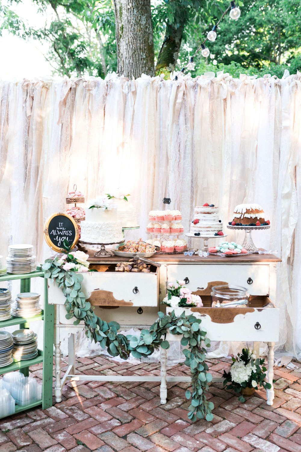 wedding dessert table with ribbon garland backdrop